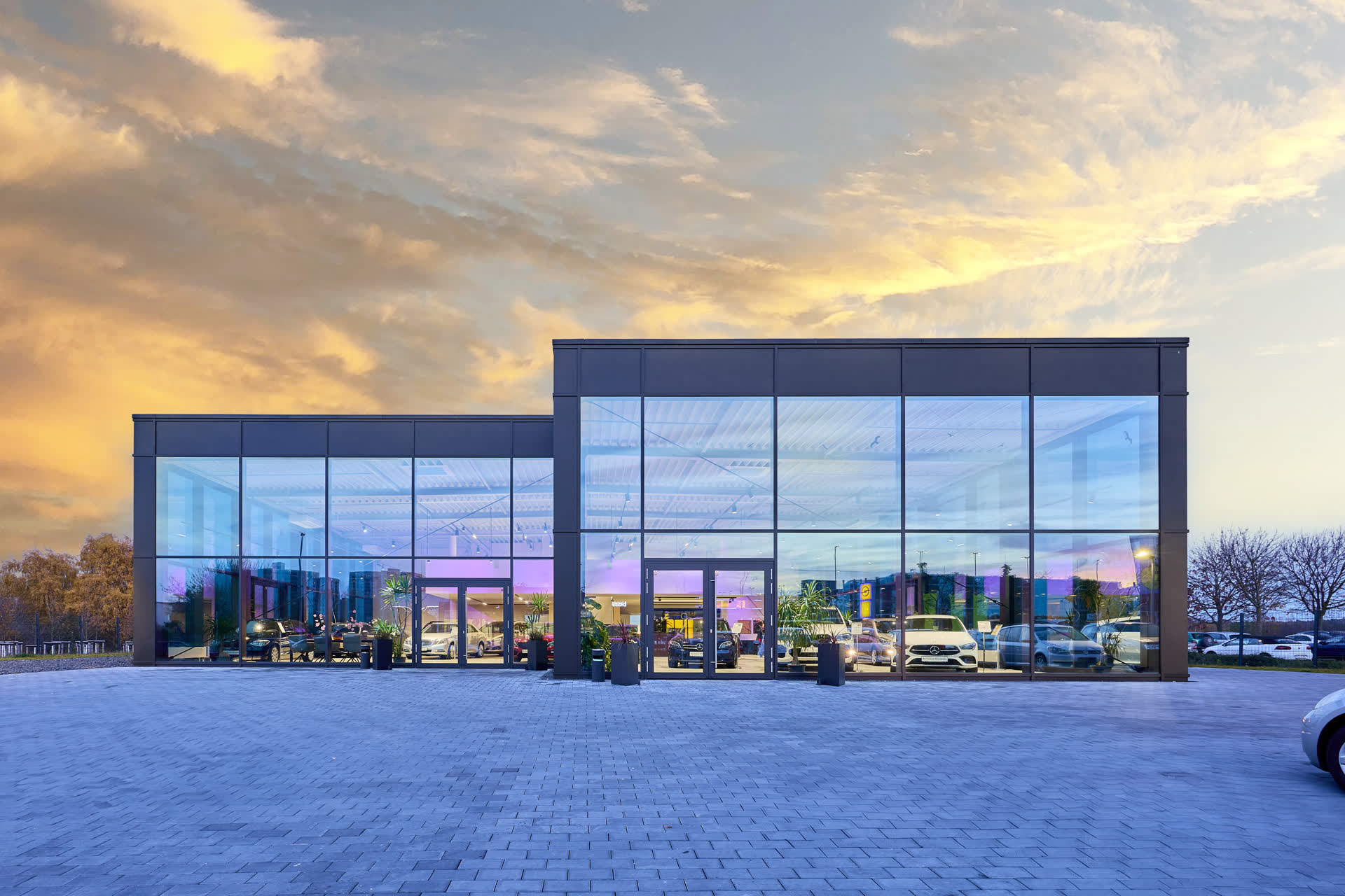 Die Glasfassade des Autohauses in der Abenddämmerung